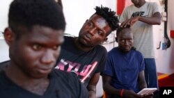 A migrants get his head shaved aboard the Ocean Viking humanitarian rescue ship, in the Mediterranean Sea, Sept. 12, 2019.