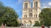 Some enjoy Notre Dame cathedral in Paris, mask-free, despite the city's surging cases. (Lisa Bryant/VOA)
