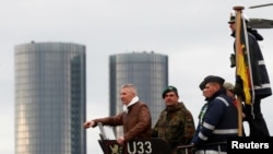 FILE - Latvian Defense Minister Artis Pabriks, left, is seen on board a German Navy submarine U-33 in Riga, Latvia, May 31, 2019.