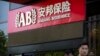 People walk past an entrance to the Anbang Insurance Group's offices in Beijing, June 14, 2017. 