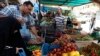 FILE - Residents shop for fruits and vegetables at a market in Baghdad's Karrada district. Iraq relies on imports from neighbors like Iran, Syria and Turkey for much of its consumer goods.