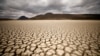 FILE - Clouds gather but produce no rain as cracks are seen in the dried up municipal dam in drought-stricken Graaff-Reinet, South Africa, Nov. 14, 2019. 