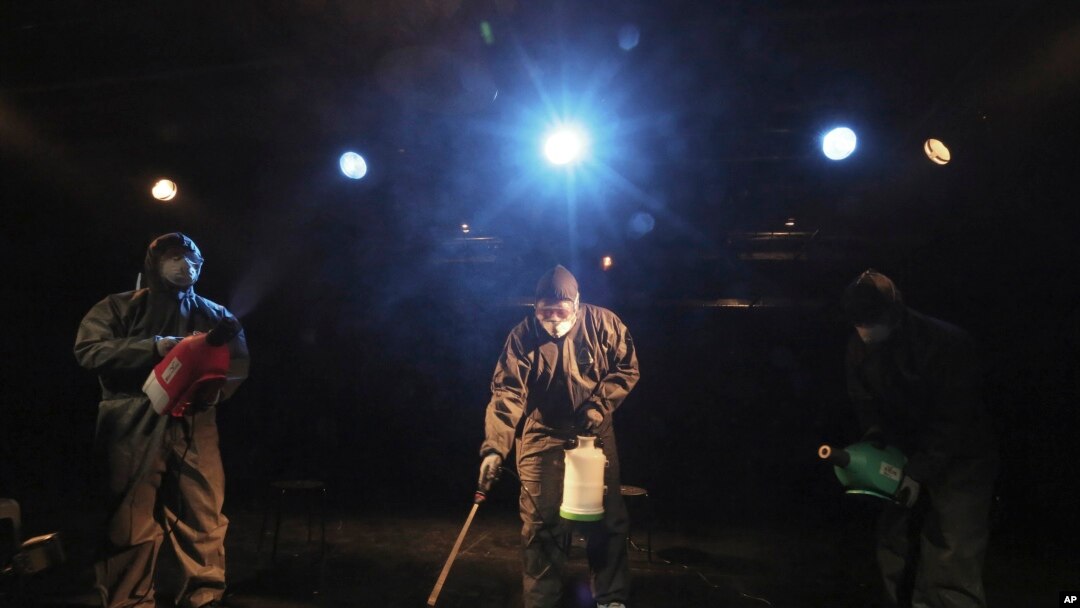 Trabajadores que usan equipo de protección desinfectante en aerosol como precaución contra un nuevo coronavirus en un teatro en Seúl, Corea del Sur, el jueves 6 de febrero de 2020. 
