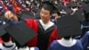 A man adjusts a student's mortar board during the graduation ceremony at Fudan University in Shanghai, June 28, 2006. (File)