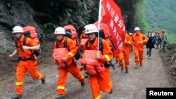 Rescuers run through wreckage to reach the isolated Baoxing county a day after an earthquake hit Ya'an, Sichuan province Apr. 21, 2013.
