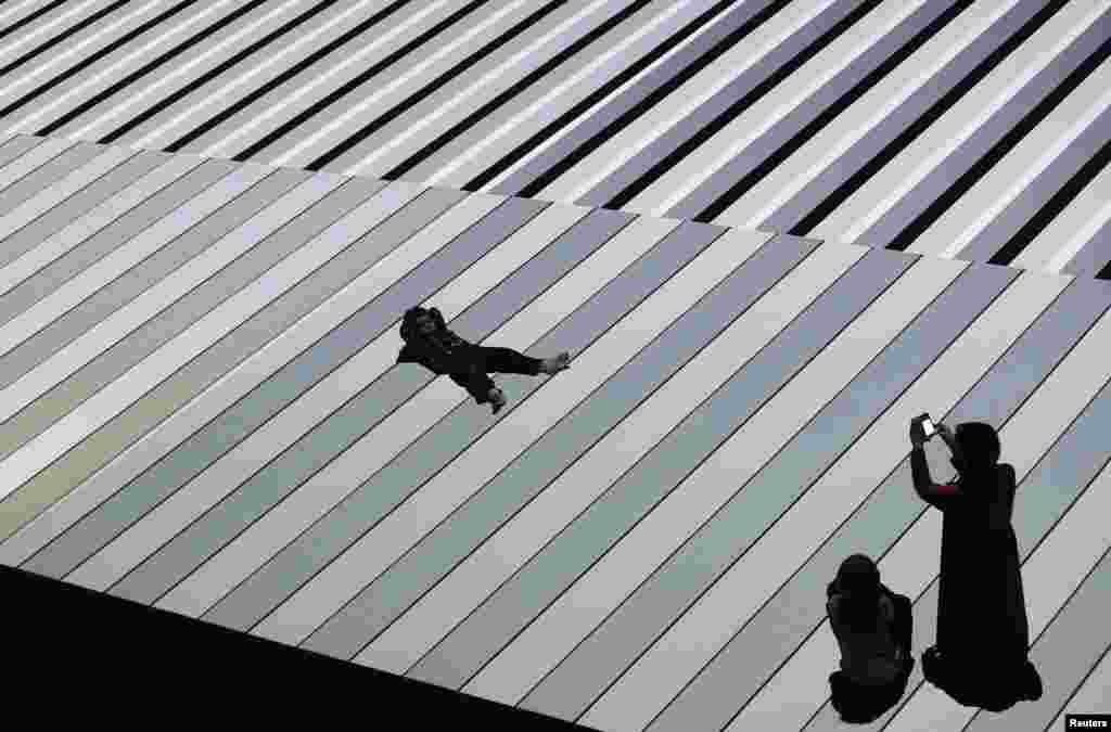 A woman takes pictures of her son as he lies down on top of 'Test Pattern', an installation by Japanese artist Ryoji Ikeda, during its opening exhibition as part of Vivid Sydney, a creative festival of light, music and ideas, that runs until June 10.