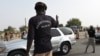 FILE - Chadian customs officers control traffic on the N'Gueli bridge, marking the border between Chad and Cameroon near N'Djamena, April 4, 2015. Traders and truck drivers took to the bridge Dec. 16, 2020, to protest COVID-imposed travel restrictions.