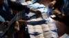 FILE - Afghan election workers count ballots during the presidential election, at a polling station in Kabul, Sept. 28, 2019. International pressure seems to have taken the steam out of a dispute that followed the election.