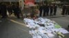 Security guards stand near protest banners and flowers laid outside the headquarters of Southern Weekly newspaper in Guangzhou, Guangdong province, China, January 7, 2013. 