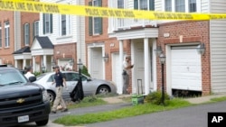 Law enforcement officers are seen outside the home of Nicholas Young, a Washington Metro Transit Officer, Aug. 3, 2016, in Fairfax, Virginia.