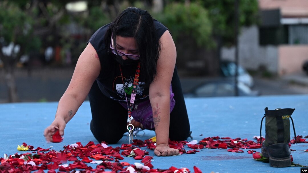 Una mujer deja pétalos de flores como recuerdo a la migrante salvadoreña Victoria Salazar en San Salvador, El Salvador, el 30 de marzo de 2021.
