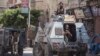 A picture taken on July 26, 2018 shows Egyptian policemen stand guarding a street in the North Sinai provincial capital of El-Arish. Reports say militants attacked a police checkpoint outside the town, June 5, 2019.