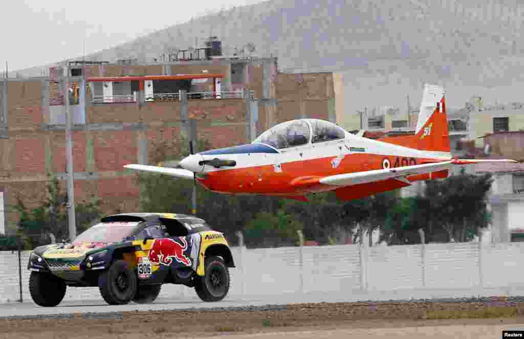 PH Sport's driver Sebastian Loeb of France and co-driver Daniel Elena of Monaco race their Peugeot against an airplane during a demonstration ride at the Las Palmas air base in Lima, Peru, Jan. 6, 2019.