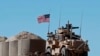 FILE - In this April 4, 2018 file photo, a U.S. soldier sits on an armored vehicle at a newly installed position, near the tense front line between the U.S-backed Syrian Manbij Military Council and the Turkish-backed fighters, in Manbij, north Syria. 