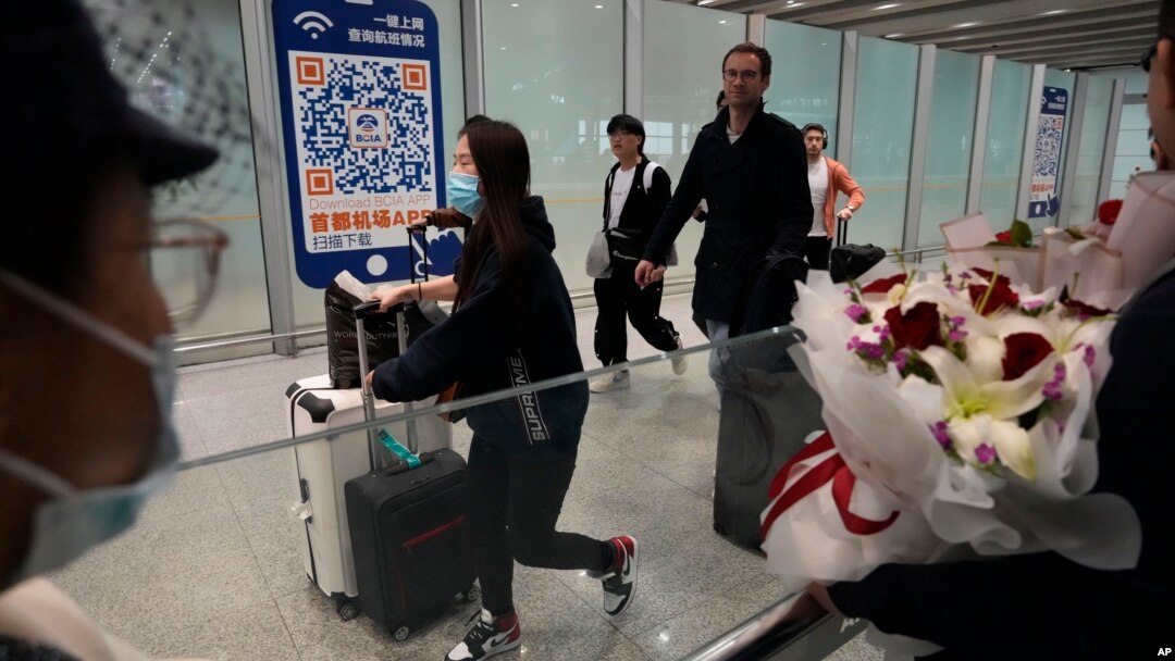 ARCHIVO - Pasajeros caminan por la terminal aérea de Beijing, el 14 de marzo de 2023.