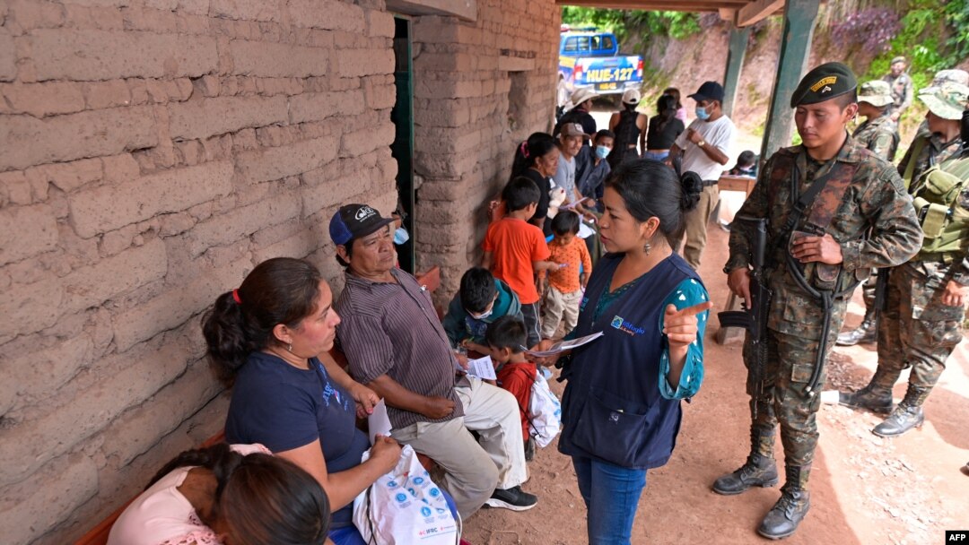 Esta fotografía publicada por la Presidencia de Guatemala muestra a un trabajador social hablando con ciudadanos mexicanos en un refugio temporal en una escuela en Nueva Reforma, Huehuetenango, Guatemala, el 27 de julio de 2024.