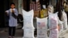 (File) A Palestinian girl walks past sacks of flour food aid from the United Nations and USAID at the Shatie refugee camp in Gaza City.
