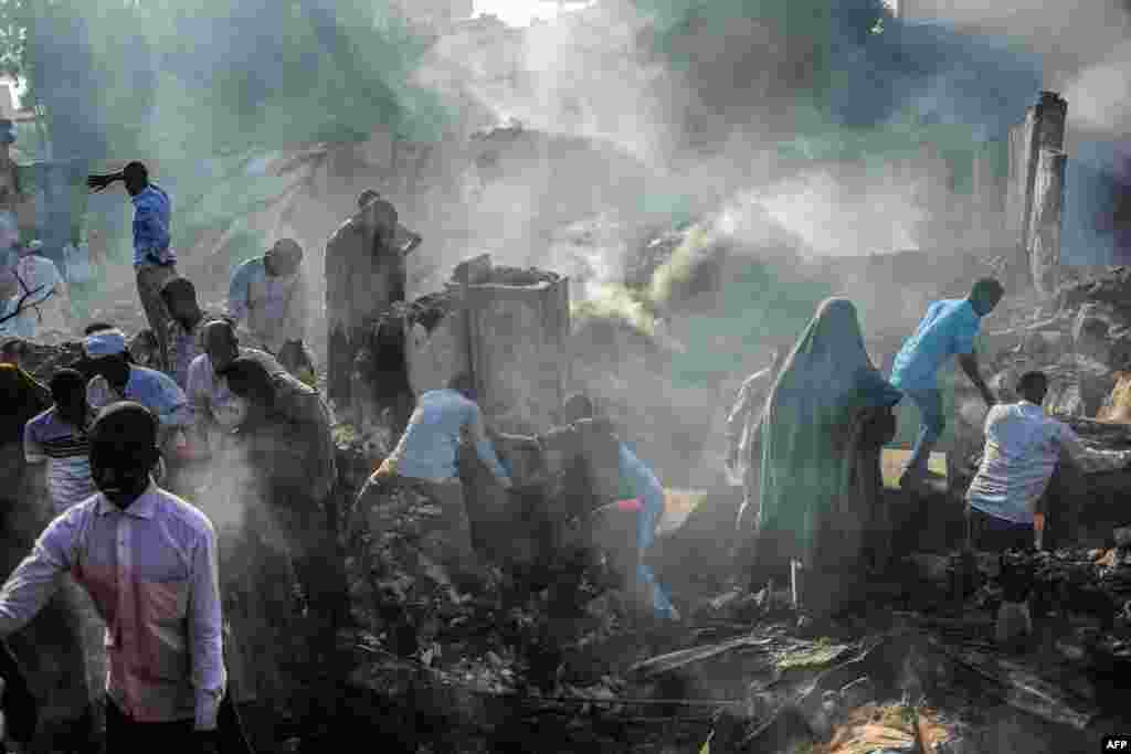 People try to recover items from the remains after a fire broke overnight in Mogadishu&#39;s biggest market, the Bakara Market, Somalia.