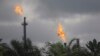 FILE - Gas flares belonging to the Agip Oil company are seen across farmland in Idu, Niger Delta area of Nigeria, Oct. 8, 2021. 