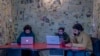 FILE- Fahad Shah, right, editor-in-chief of Kashmir Walla, works on his computer inside the newsroom at his office in Srinagar, Indian controlled Kashmir, Friday, Jan. 21, 2022. 