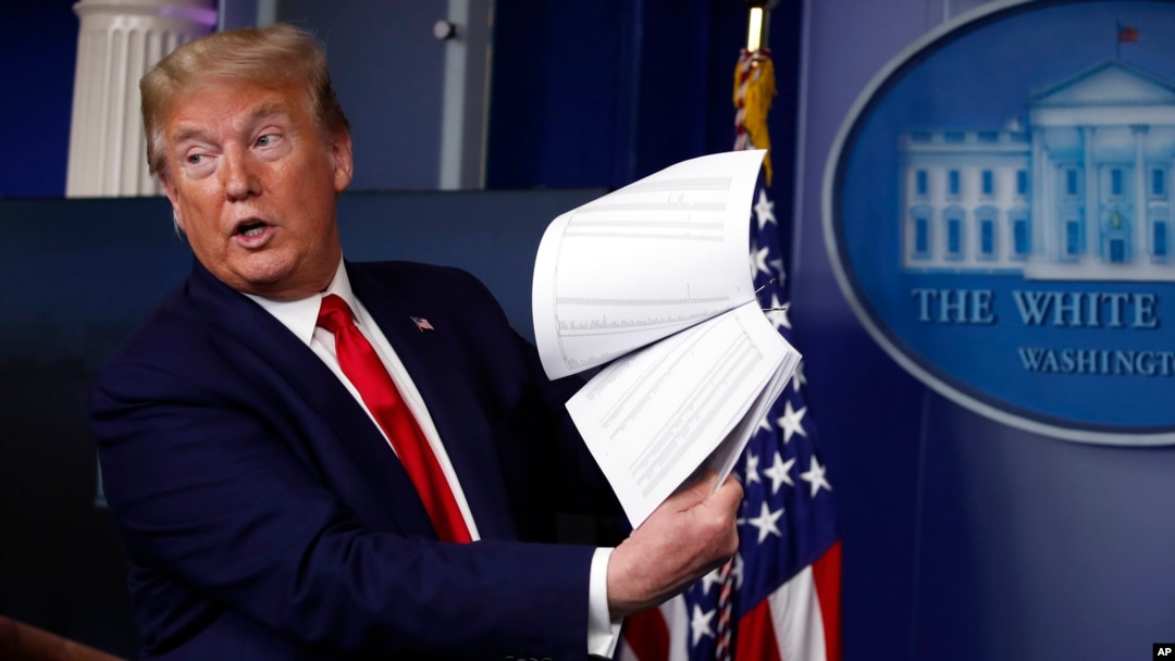 ARCHIVO - El presidente Donald Trump sostiene papeles mientras habla sobre el coronavirus en la sala de conferencias de prensa James Brady de la Casa Blanca el 20 de abril de 2020 en Washington.