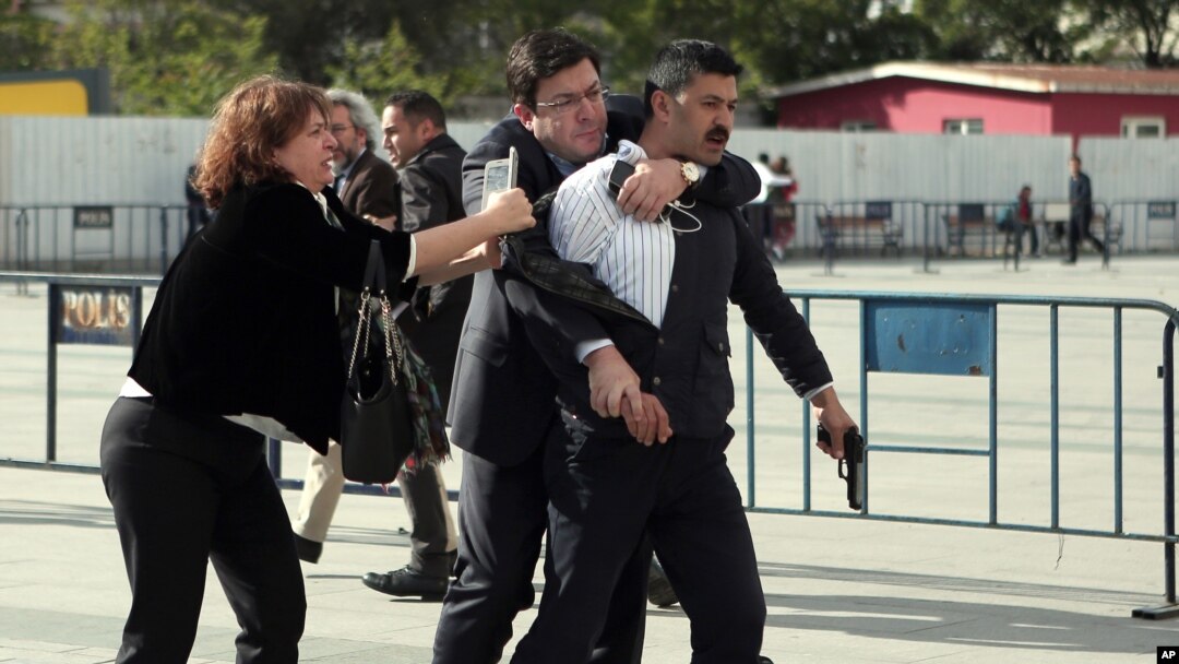 Dilek Dundar, journalist Can Dundar's wife, and his lawyer, second left, overpower a gunman just after the attack on Can Dundar outside the city's main courthouse in Istanbul, May 6, 2016.