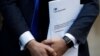 Conservative Party politician Steve Baker holds a Brexit document as British Member of Parliament, Jacob Rees-Mogg, speaks from St Stephen's Entrance at the Houses of Parliament, in London, Britain, Nov. 15, 2018. 