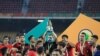 FILE - Morocco's coach Houcine Ammouta (C) holds up the trophy after his team's win during the African Nations Championship (CHAN) final football match between Morocco and Mali at Stade Ahmadou Ahidjo in Yaounde, Cameroon, Feb. 7, 2021.