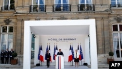 French President Emmanuel Macron speaks flanked by Defense Minister Florence Parly (L) and Junior Minister of Remembrance and Veterans Affairs Genevieve Darrieussecq (R) during an address to France's armed forces, July 13, 2020.