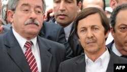 FILE - Then Algerian prime minister Ahmed Ouyahia (L) stands next to Said Bouteflika, brother of the then Algerian president Abdelaziz Bouteflika, in Algiers, May 19, 2012.