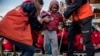 A migrant child is helped from the Spanish NGO Proactiva Open Arms rescue vessel, after being rescued Dec. 21, in the Central Mediterranean Sea, to disembark in the port of Crinavis in Algeciras, Spain, Dec. 28, 2018.
