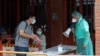 Medical personnel wearing protective gear, guide people at a rapid coronavirus testing center after the infection alert rose to level 3 in Taipei, Taiwan, May 18, 2021.