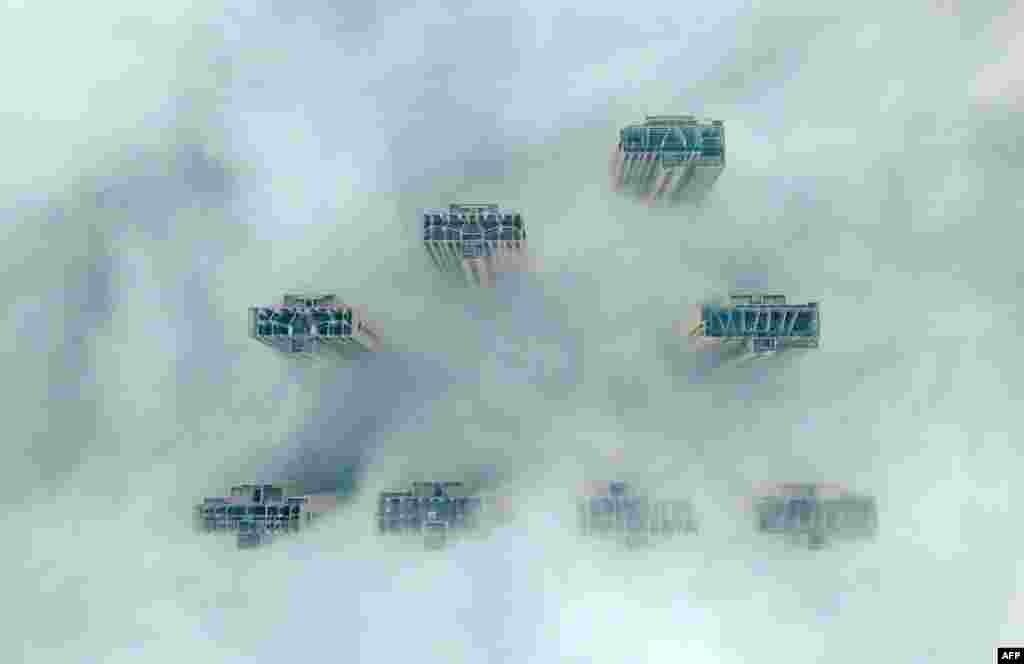 This aerial view shows the tops of high-rise buildings poking out from heavy fog in Yangzhou, in China's eastern Jiangsu province.