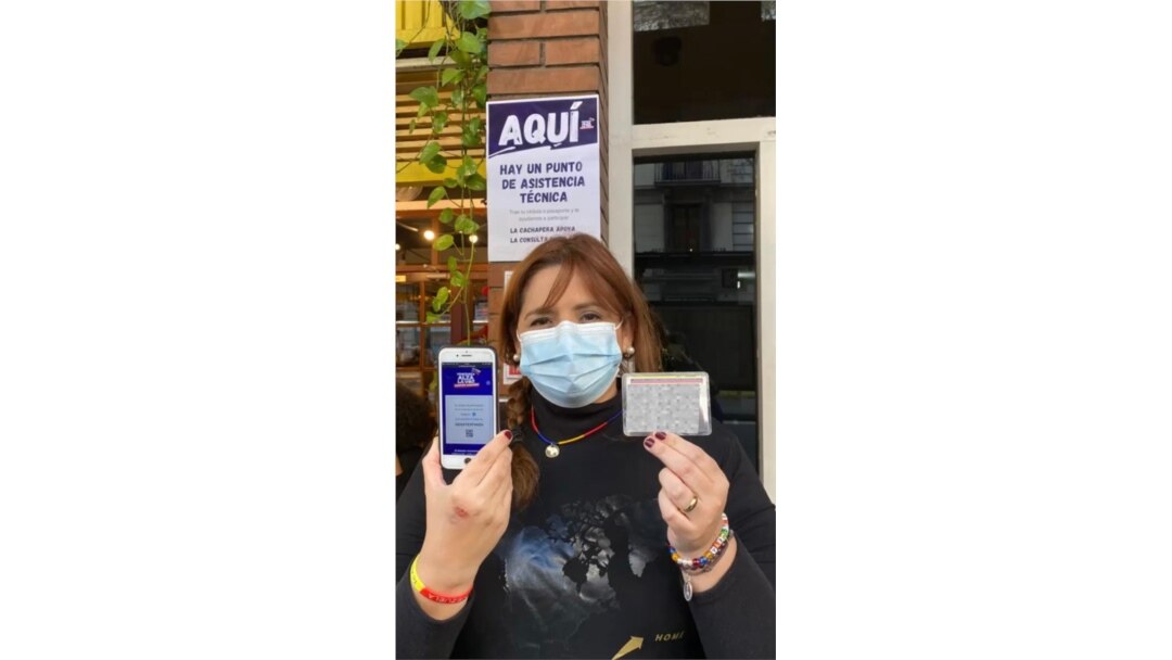 Mariela Díaz muestra su teléfono y su cédula después de haber votado. [Foto: VOA/Júlia Riera].
