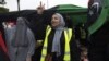 Libyans women, some wearing yellow vests, carry national flags as they chant slogans during a demonstration against strongman Khalifa Haftar in the capital Tripoli's Martyrs' Square on April 26, 2019. 
