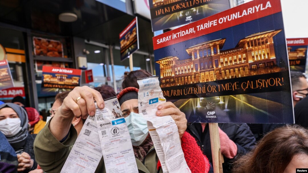 9 Şubat 2022 - İstanbul'da bir kadın, yüksek elektrik fiyatlarını protesto amacıyla elektrik faturalarını gösteriyor. 