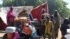 FILE - Cameroonians who fled deadly intercommunal violence between Arab Choa herders and Mousgoum and Massa farming communities stand beside their makeshift shelters on the outskirts of Ndjamena, Chad, Dec. 13, 2021.