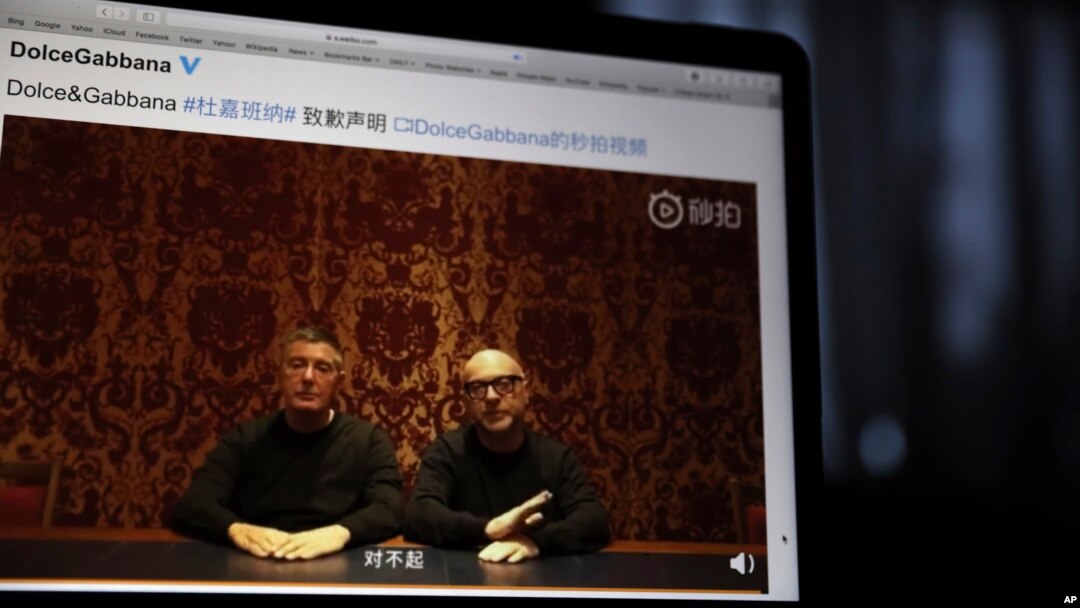 Founders of Dolce&Gabbana Domenico Dolce, left, and Stefano Gabbana apologize in a video on Chinese social media, saying "sorry" in Mandarin seen on a computer screen in Beijing, China, Friday, Nov. 23, 2018.