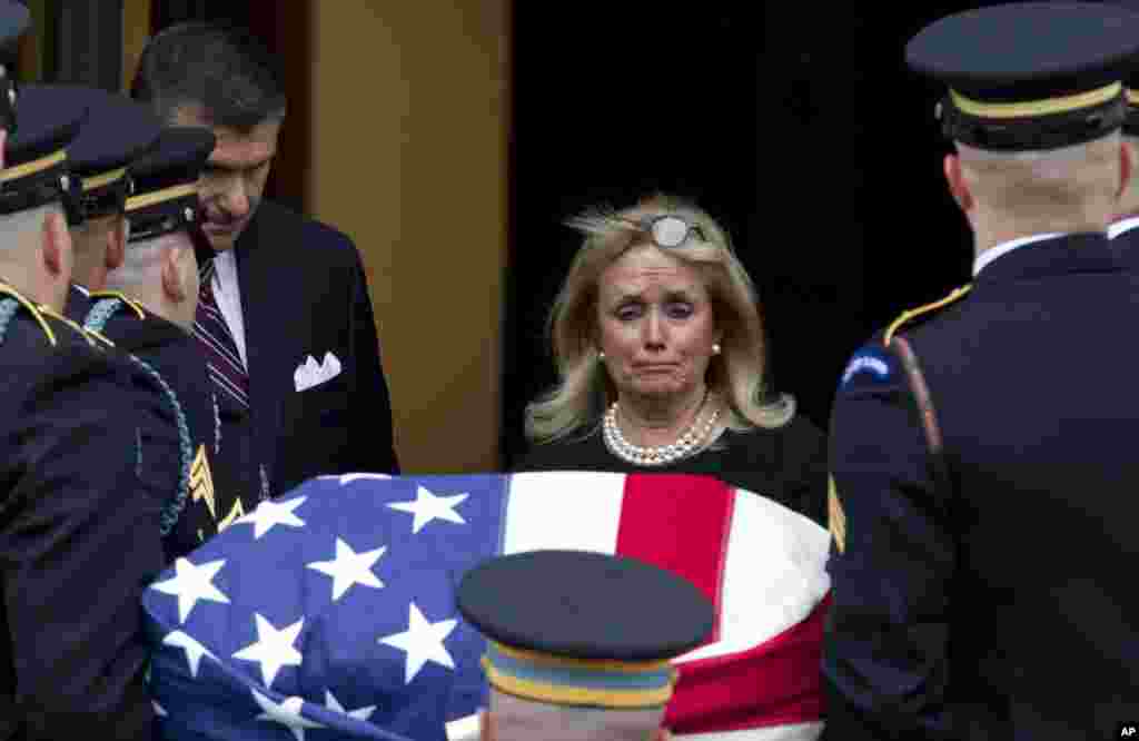 Rep. Debbie Dingell, D-Mich., watches the flag-draped casket of her late husband former Rep. John Dingell upon arrival at Holy Trinity Catholic Church for a funeral service, in Washington. Dingell, the longest-serving member of Congress in American history who mastered legislative deal-making and was fiercely protective of Detroit's auto industry, has died at age 92.