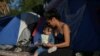 En esta foto de archivo, una madre y su hija permanecen en un campamento improvisado ocupado por solicitantes de asilo rechazados por Estados Unidos, en Tamaulipas, México, el 27 de octubre de 2019.