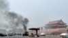 Vehicles travel along Chang'an Avenue as smoke raises in front of a portrait of late Chinese Chairman Mao Zedong at Tiananmen Square in Beijing, Oct. 28, 2013.