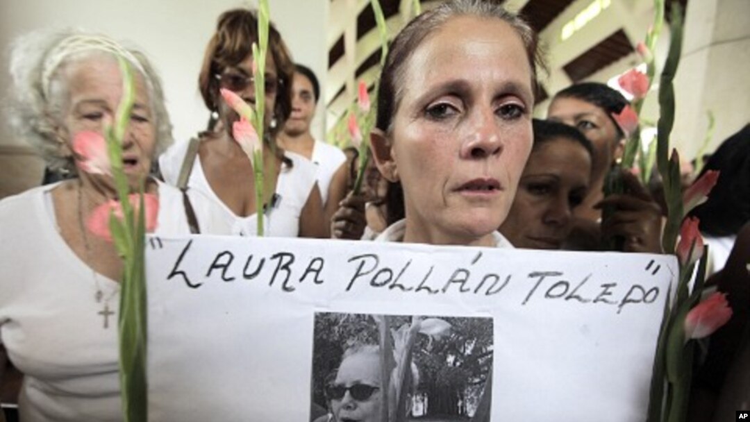 A member of the Ladies in White holds a picture of leader Laura Pollan, inside a church after a march in homage of Laura Pollan, along the main avenue of the upscale Havana district of Miramar in Havana, October 16, 2011.