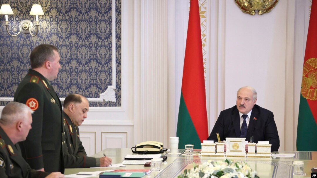 FILE - Belarusian President Alexander Lukashenko, right, attends a meeting with military top officials in Minsk, Belarus, Monday, Oct. 10, 2022.