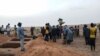 FILE - Officials and residents stand near freshly dug graves on June 11, 2019, in a Dogon village in Mali, after an attack on ethnic Dogon on June 9, 2019. 