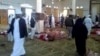 WARNING: Graphic content - Egyptians walk past bodies following a gun and bombing attack at the Rawda mosque, roughly 40 km west of North Sinai capital of El-Arish, on Nov. 24, 2017.