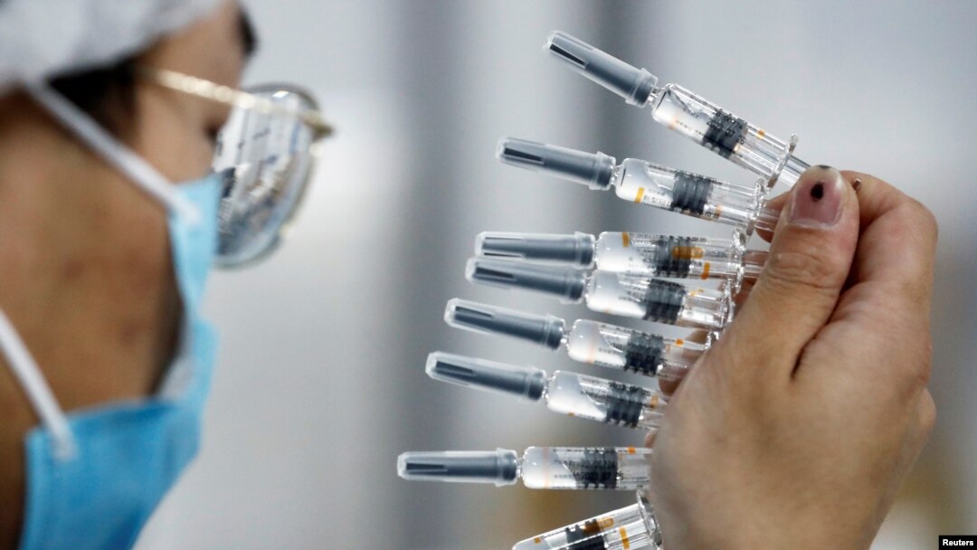A worker performs a quality check in the packaging facility of Chinese vaccine maker Sinovac Biotech, developing an experimental coronavirus disease (COVID-19) vaccine, during a government-organized media tour in Beijing, Sept. 24, 2020.
