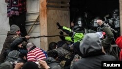 Los partidarios del presidente de los Estados Unidos, Donald Trump, se enfrentan a la policía en la entrada oeste del Capitolio durante una protesta "Stop the Steal" frente al edificio del Capitolio en Washington DC, el 6 de enero de 2021.