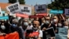 FILE - Media workers, holding signs reading "We can't breathe" protest government pressure on free speech and independent media, during a rally in Istanbul, Turkey, June 29, 2021. 