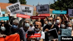 FILE - Media workers, holding signs reading "We can't breathe" protest government pressure on free speech and independent media, during a rally in Istanbul, Turkey, June 29, 2021. 