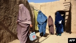 Afghan women wearing burqas from a polio immunization team walk together during a vaccination campaign in Kandahar, Oct. 15, 2019. Polio immunization is compulsory in Afghanistan, but distrust of vaccines is rife.
